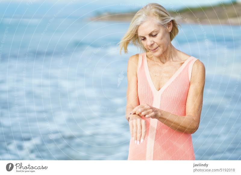 Ältere Frau am Ufer eines Strandes. Ältere Frau, die ihren Ruhestand an einem Strandort genießt. reif Senior alt Person Lifestyle Glück MEER Feiertag
