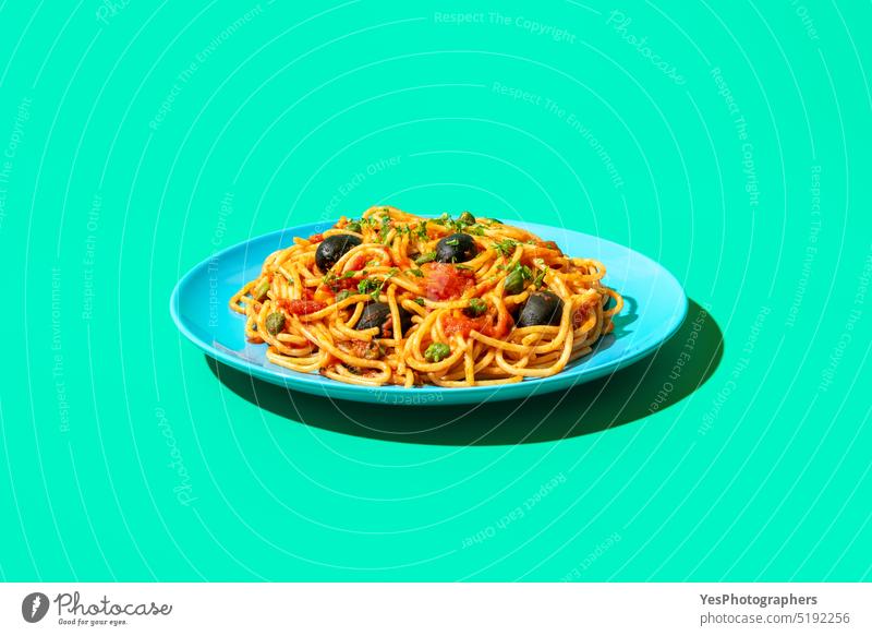 Spaghetti puttanesca Teller in hellem Licht, minimalistisch auf einem grünen Hintergrund blau Kapriolen Kohlenhydrate Nahaufnahme Farbe gekocht Textfreiraum