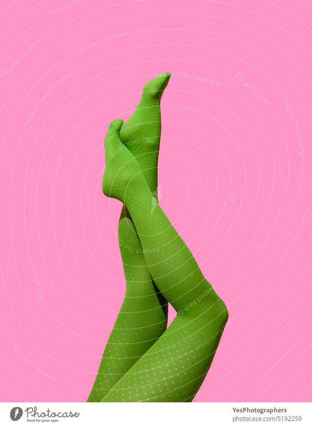 Frau Beine in grünen Strumpfhosen isoliert auf einem rosa Hintergrund 40s sportlich schön Schönheit Körper hell Pflege Kleidung Farbe Konzept Textfreiraum