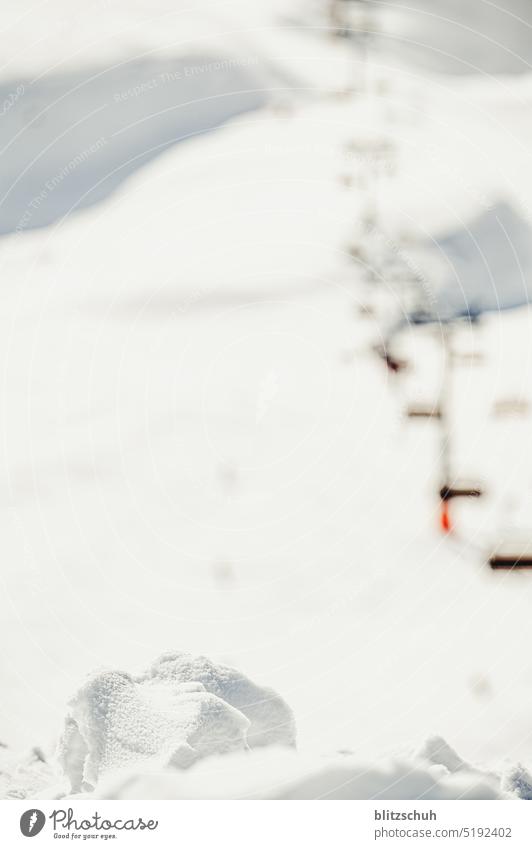 Schneebrocken im Hintergrund ein Sessellift Skilift Sesselbahn Winter Berge u. Gebirge kalt Alpen Ferien & Urlaub & Reisen Winterurlaub Skifahren Landschaft