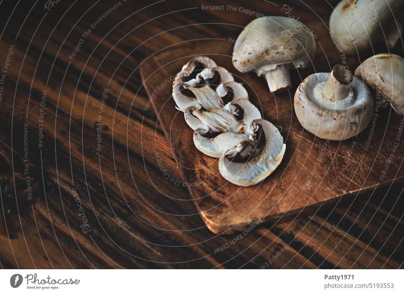 Weisse Champignons auf einem dunkeln, rustikalen Holzbrett Lebensmittel Pilz Ernährung Vegetarische Ernährung Foodfotografie Gesunde Ernährung Bioprodukte weiss