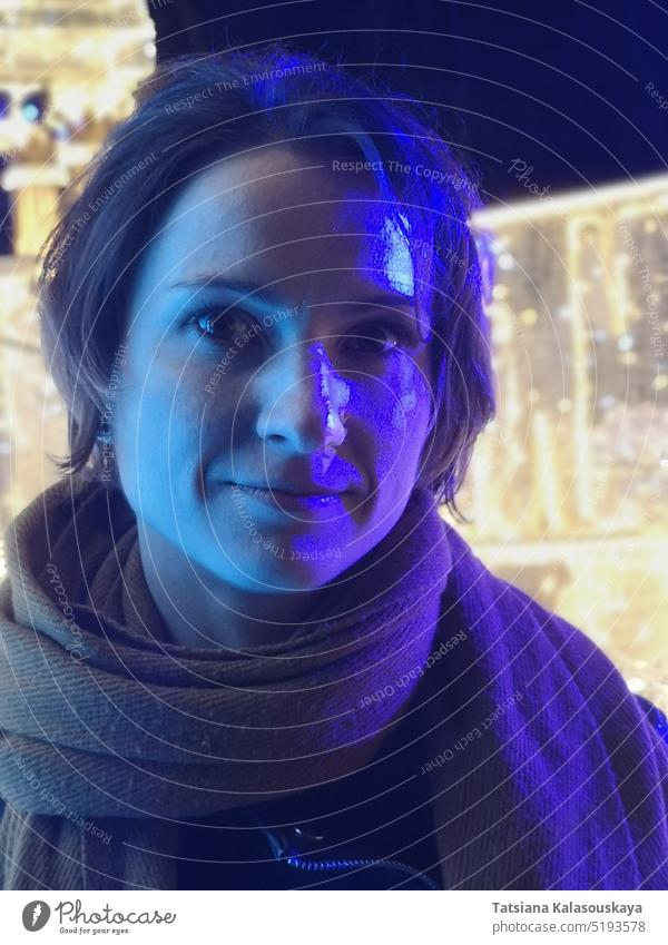 Lila Neonlicht beleuchtet das Gesicht einer jungen dunkelhaarigen Frau blau purpur neonfarbig aufleuchten Porträt Neon-Beleuchtung neonfarben Licht Farben