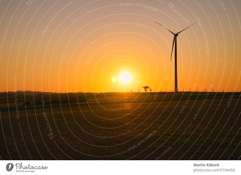 Onshore-Windkraftanlage auf einer Wiese bei Sonnenuntergang. Erneuerbare Energie. Sauberer Strom an Land saubere Energie zweite Änderung Netzbetreiber