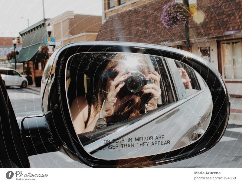 Eine Frau, die sich im Rückspiegel eines Autos spiegelt, macht ein Foto auf der Route 66. Spiegel Fotografie Spiegelbild Fotokamera Fotografieren