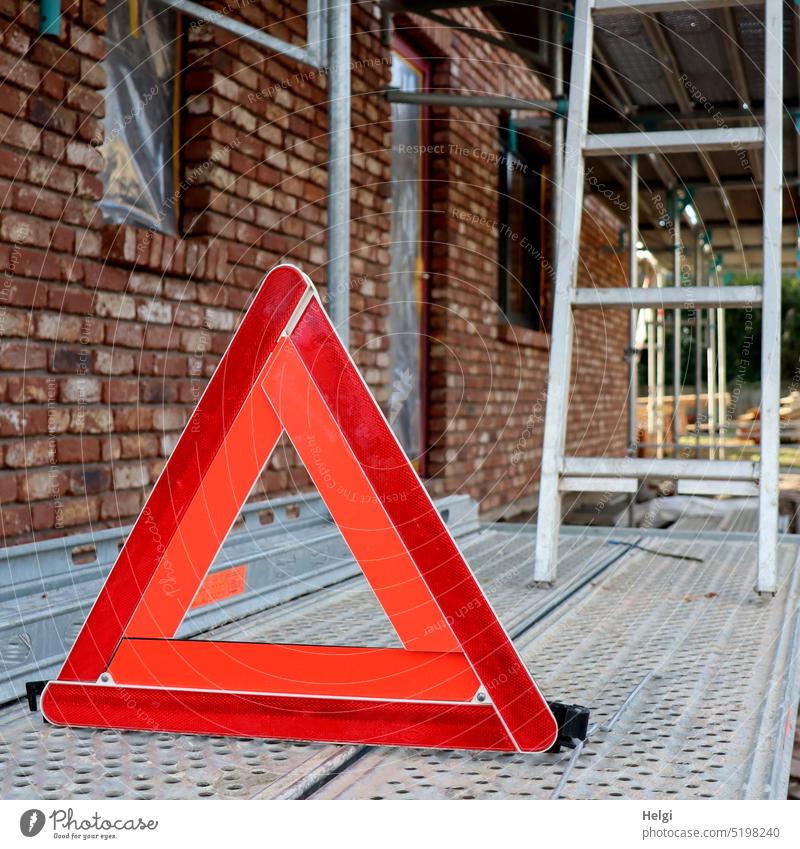 Achtung! Gefahr! - rotes Warndreieck steht auf einem Gerüst an einer Baustelle Warnung Dreieck Gefahrenstelle aufpassen Gebäude Metall Kunststoff Warnhinweis