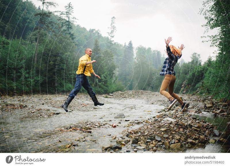 Playful glücklich gut aussehend Paar beim Spaziergang im Wald haben. Abenteuer in der Natur Konzept. Glück aktiv Partnerschaft Wälder Liebe gutaussehend