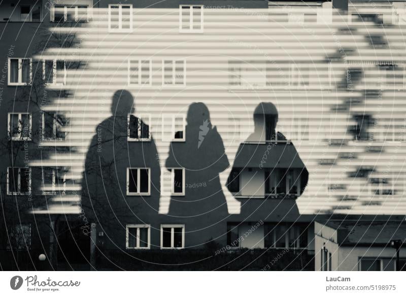 Scherenschnitt - drei Personen werfen ihre Schatten voraus Silhouette Schattenspiel Fassade Fenster Strukturen & Formen Trio Schatten vorauswerfen Licht