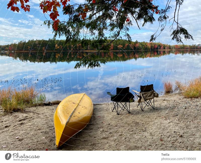 Herbstszene im Kejimkujik National Park.  Leuchtend gelbes Kanu und Campingstühle am Strand. See Herbstlaub Urlaub Erholung Natur Landschaft