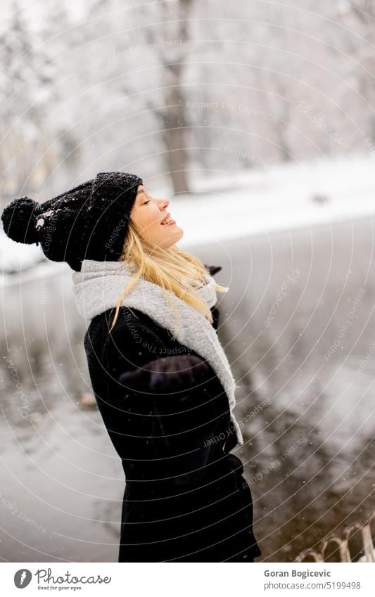 Junge Frau in warmer Kleidung genießt im Schnee Schönheit Model Mädchen Person jung Winter Natur im Freien Glück weiß Frost Saison Tag Gefühle Mantel