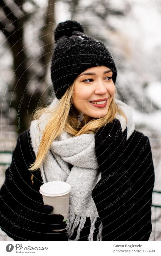 Junge Frau mit warmer Kleidung im kalten Winter Schnee trinken Kaffee zu gehen Erwachsener schwarz Bekleidung Mantel kalte Temperatur Handschuh Hut eine Person