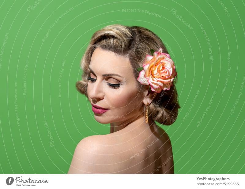 Pin-up-Frau Porträt mit Retro-Frisur und Make-up, vor einem grünen Hintergrund 40s 50s Zubehör Schönheit blond zugeklappt Farbe Konzept Textfreiraum lockig