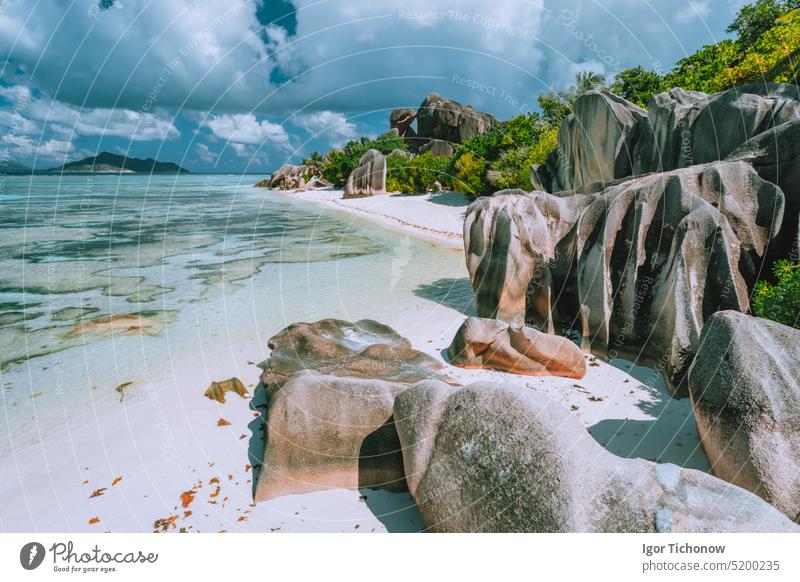 Insel La Digue, Seychellen. Schöner Blick auf den paradiesischen Strand Anse Source d'Argent mit flacher blauer Lagune, Granitblöcken und Wolken Feiertag Urlaub