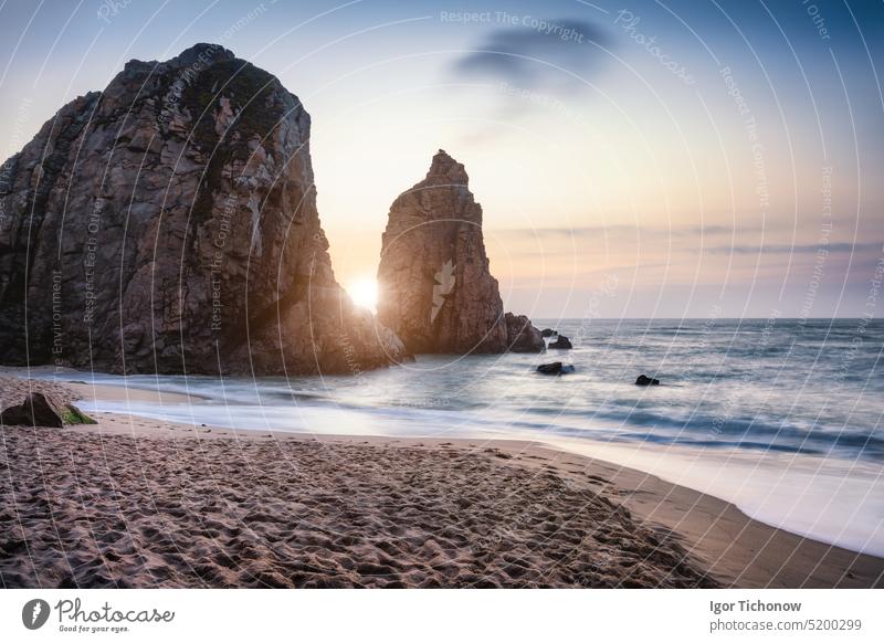 Sonnenuntergang am Strand von Ursa Sea stack, Portugal. Atlantischer Ozean Schaumige Wellen rollen an den Sandstrand. Urlaub Urlaub Landschaft Szene ursa Küste