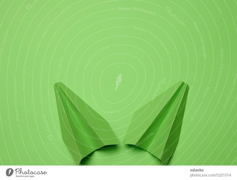 Grünes Papierflugzeug auf einem grünen Hintergrund, Reisekonzept, Draufsicht. Raum kopieren Reisebericht Ausflug Urlaub wandern Fernweh Fliege Flucht Reiseroute
