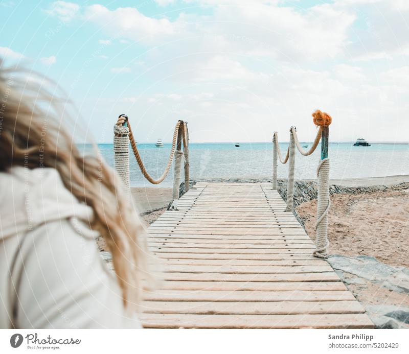 Mädchen mit blonden Haaren verlässt einen Steg, der zum Meer führt Wasser junge Frau blond Urlaub Himmel Ferien & Urlaub & Reisen Strand Außenaufnahme Sommer