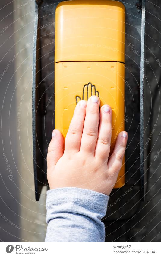 Kinderhand betätigt den Anforderungstaster einer Fußgängerampel Ampelschalter drücken handauflegen Nahaufnahme Hand Farbfoto Außenaufnahme Detailaufnahme