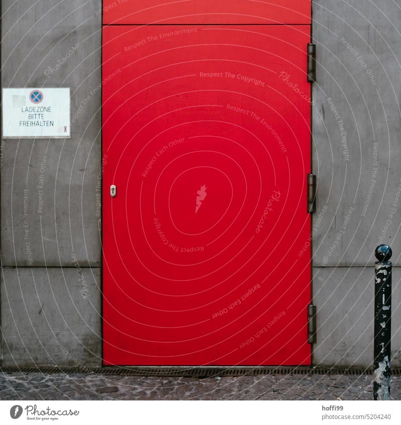 Parken verboten Ladezone mit graue Wand und roter Tür rote Tür trist ladezone parken verboten Schild Verbot Verbotsschild Hinweisschild Warnschild Verbote