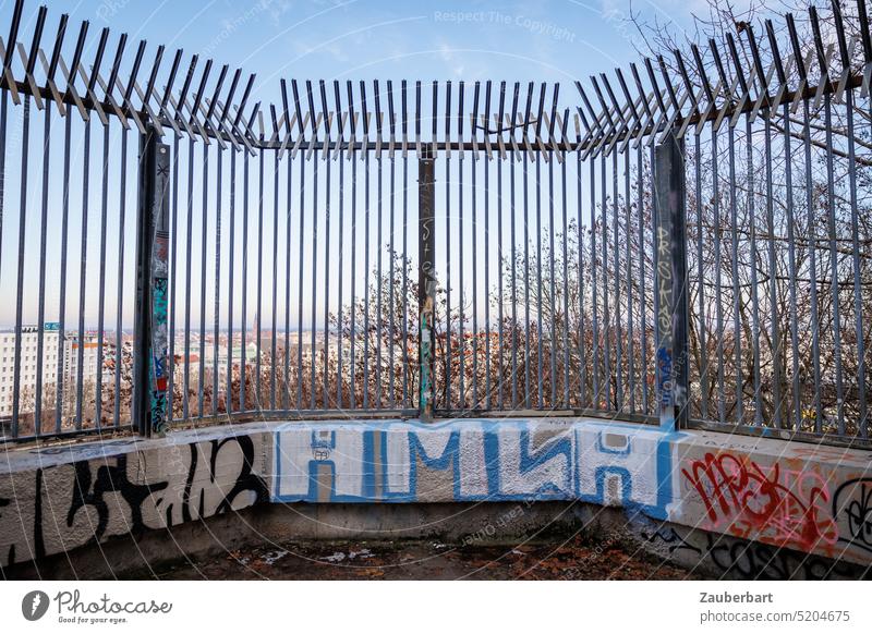 Gitter zur Absperrung auf Betonsockel mit Graffiti über der Stadt Sperre gefangen Sockel hoch Gefängnis Hindernis überwinden Zaun Barriere Sicherheit Schutz