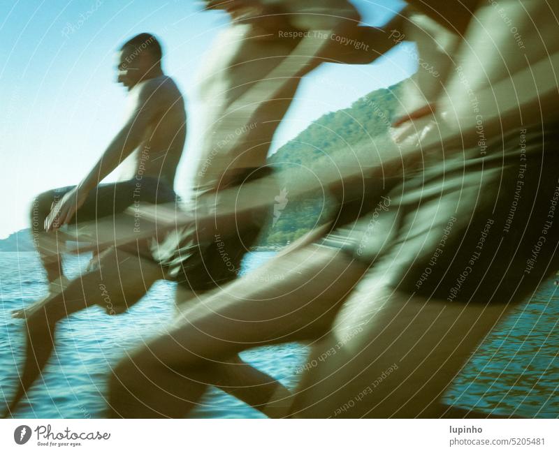 Drei Jungs nehmen Anlauf zum Sprung ins Meer Wasser Sommer Bewegungsunschärfe laufen Spätnachmittagslicht Urlaub Freude Spaß blaugrün Action