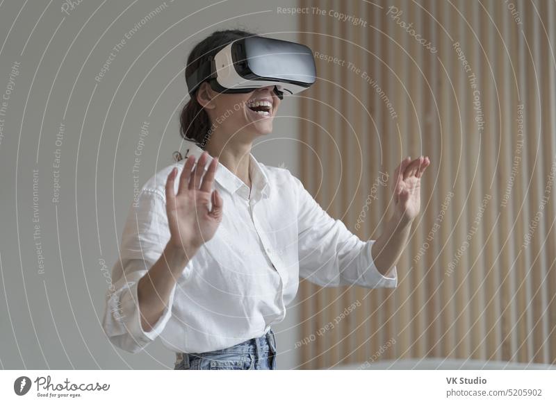 Beeindruckte, erstaunte Büroangestellte mit VR-Brille bei der Arbeit in der Augmented-Reality-Welt virtuell Realität Frau Mitarbeiter Geschäftsfrau Headset