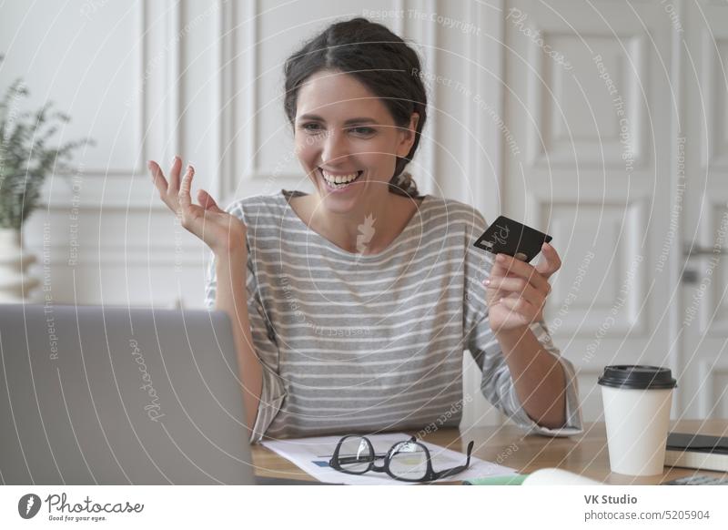 Junge lächelnde italienische Frau beim Bezahlen mit Plastikkarte beim Online-Shopping am Laptop Glück online kaufen Herstellung Zahlung Kunststoff Postkarte