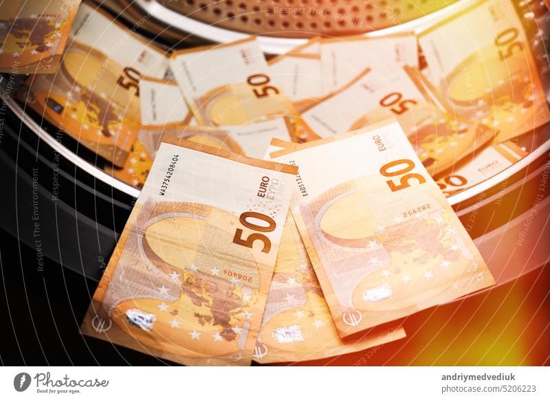 Symbol für Geldwäsche, 50-Euro-Banknoten in einer Waschmaschine. Steuerhinterziehung. Illegale Finanztransaktionen. Euro-Währung Maschine Waschen Business