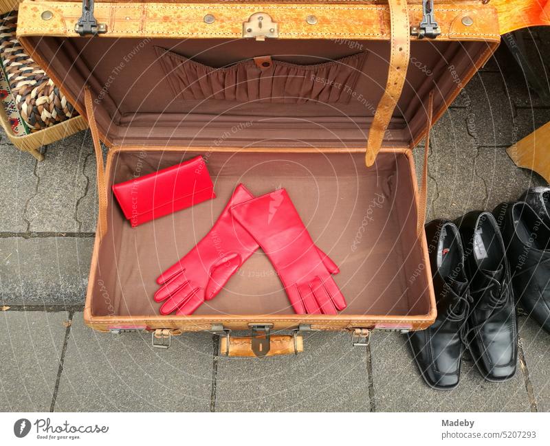 Alter brauner Koffer mit roten Handschuhen und schwarzen Schuhen im Sommer auf dem Flohmarkt und Trödelmarkt beim Oldtimertreffen Golden Oldies in Wettenberg Krofdorf-Gleiberg bei Gießen in Hessen