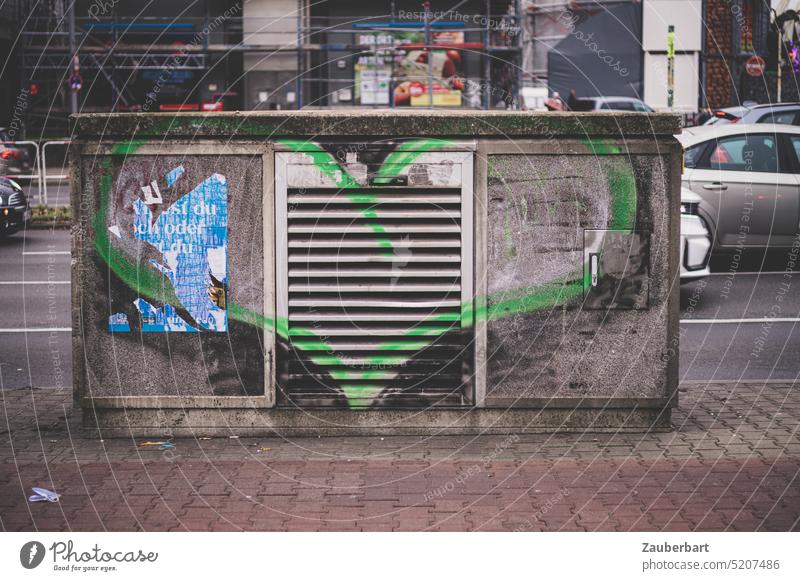 Grünes Herz auf einem Schaltkasten vor einer Straße grün Kasten Liebe herzlich Überraschung Multifunktionsgehäuse MFG Graffiti Kunst urban dreckig Bürgersteig