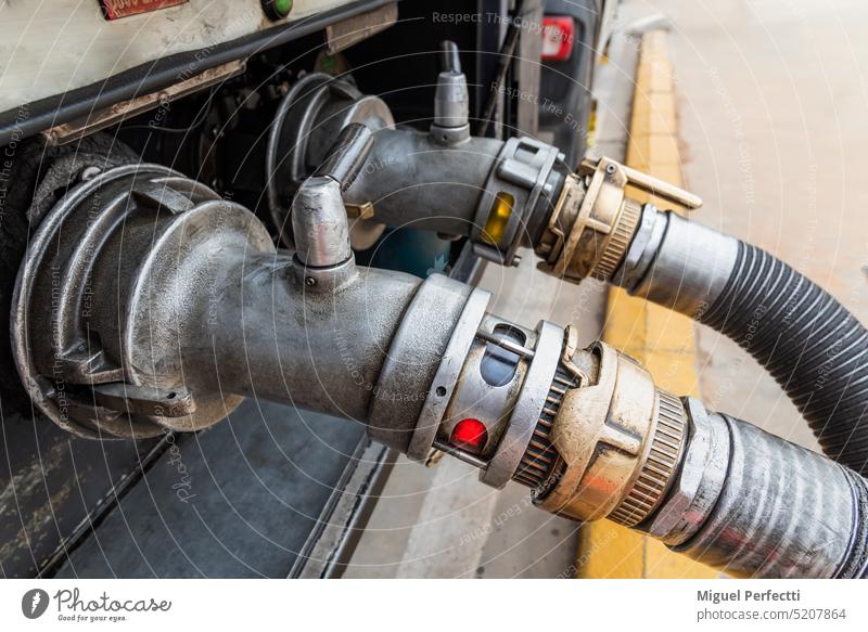 An den Mündungen eines Tankwagens angebrachte Vorrichtungen zum Anschluss der Entladeschläuche, die im Hintergrund subventionierten Diesel (Diesel B oder rot) und normalen Diesel (Diesel A) entladen.