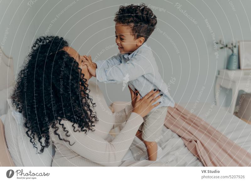 Schwangere afroamerikanische Frau spielt mit ihrem Sohn zu Hause Familie Afrikanisch schwanger Mutter niedlich Junge wenig Ausgaben Mama Kind umarmend