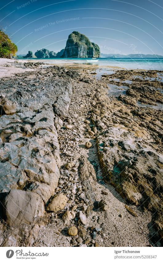 Die felsige Küstenlinie führt zur wunderschönen Insel Pinagbuyutan im Hintergrund. Traumhafte Landschaftskulisse in El Nido, Palawan, Philippinen palawan Strand