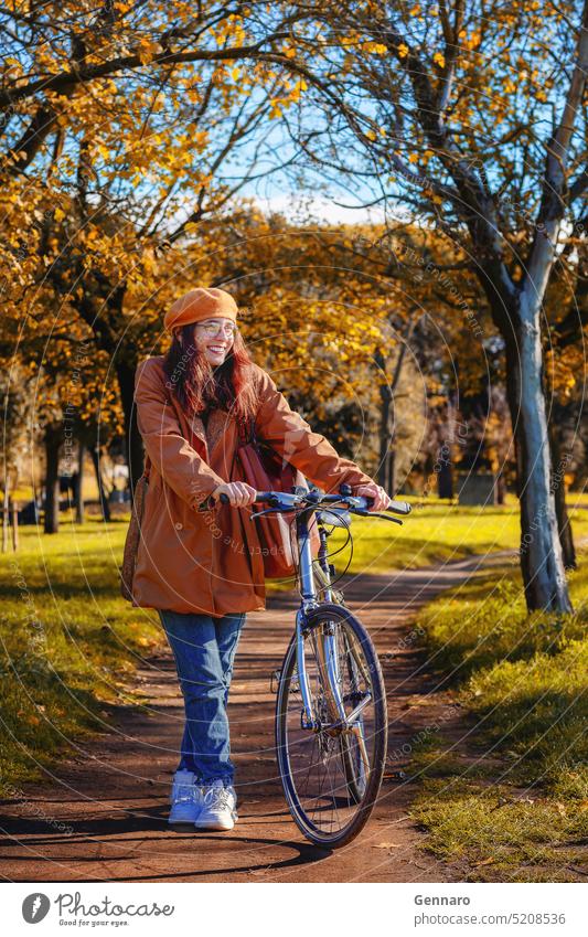 Mädchen mit Fahrrad im Park Freizeit Gesundheit im Freien Lifestyle Herbst Baskenmütze Niederlassungen braun lässig Mantel Farben Trockene Blätter Laubwerk