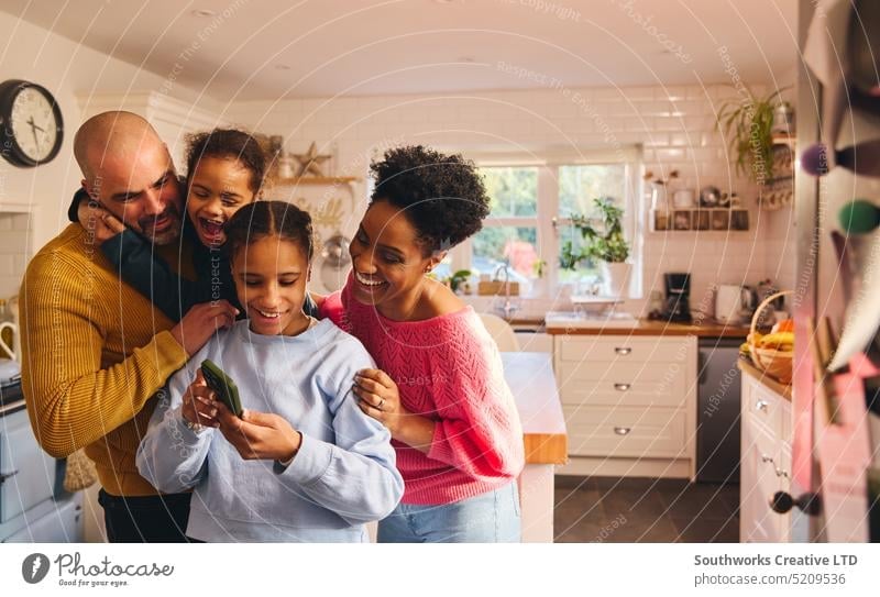 Teenager-Mädchen betrachtet Selfie auf Telefon mit Familie Aussehen Zelle Mobile Tochter Eltern Sohn Down-Syndrom Lifestyle rassenübergreifend schwarz Frau Mann