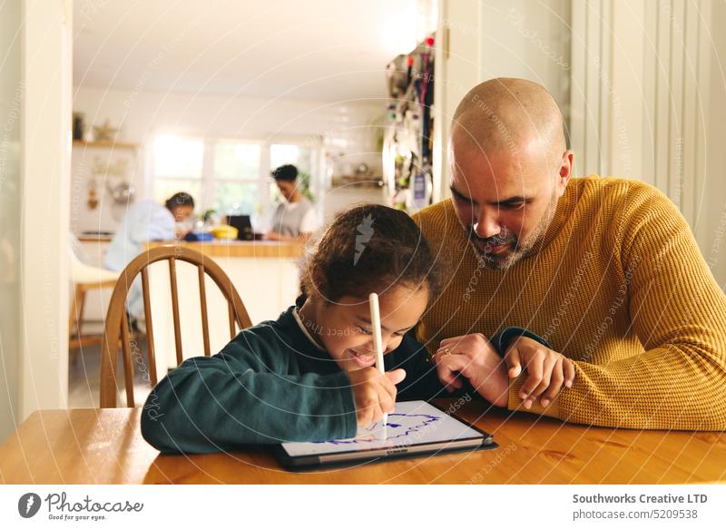 Mehrrassiger Vater und Sohn mit Down-Syndrom bei den Hausaufgaben mit einem digitalen Tablet Familie digitales Tablett Lifestyle zeichnen rassenübergreifend
