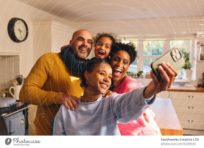 Teenager-Mädchen nimmt Selfie auf dem Handy mit glücklichen lächelnden Familie Glück Telefon Zelle Mobile Tochter Eltern Sohn Down-Syndrom Lifestyle