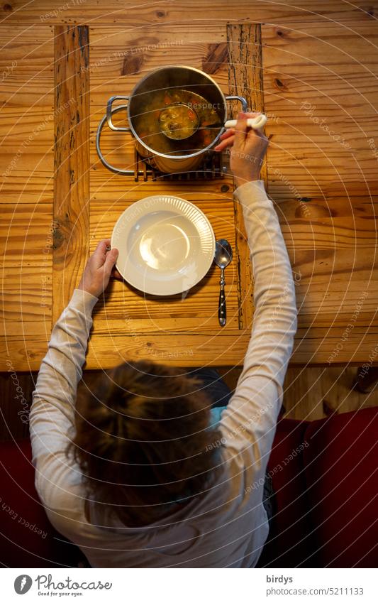 Eintopf essen Essen Holztisch Gedeck Topf Mittagessen auftun Suppe Gesunde Ernährung Einschenken Frau Single Esstisch Teller Löffel schöpfen Geschirr