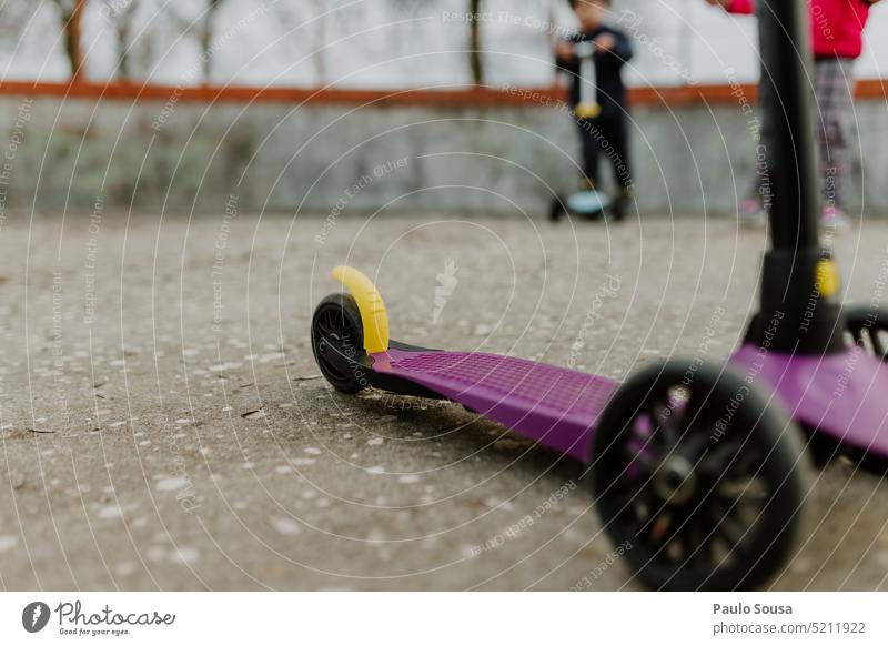 Rückansicht Kind spielt mit Roller Scooter für Kinder Spielzeug Sport Kindheit unkenntlich Aktivität Spaß Lifestyle spielen Freizeit Park Spielplatz niedlich