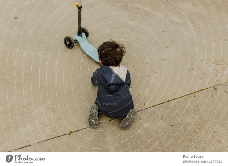 Rückansicht Kind spielt mit Roller Scooter für Kinder Spielzeug Sport Kindheit unkenntlich Aktivität Spaß Lifestyle spielen Freizeit Park Spielplatz niedlich