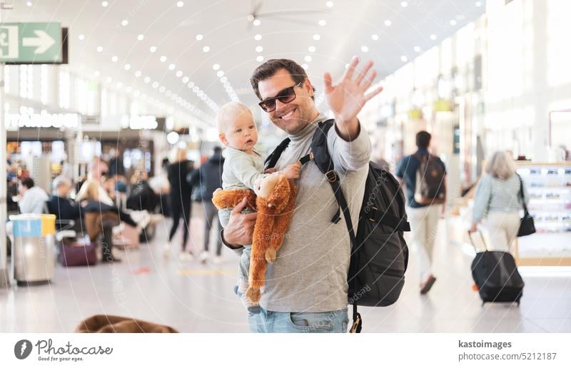 Vater reist mit Kind, hält seinen kleinen Jungen am Flughafen-Terminal warten, um ein Flugzeug zu besteigen winken goodby. Reisen mit Kindern Konzept. reisen