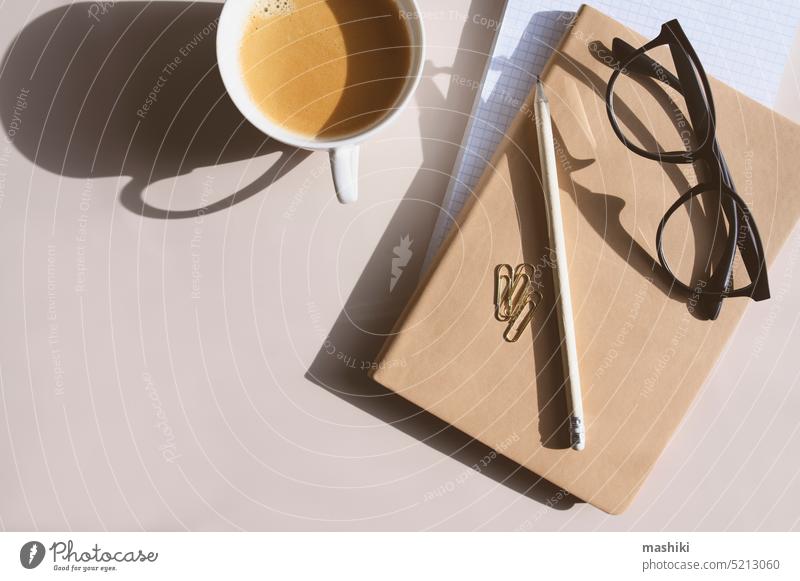 Ästhetischer minimalistischer Arbeitsbereich. Home Office, Blog, Social Media Konzept. Notizbuch, Kaffee und Gläser in weichen Pastellfarben Ästhetik modern