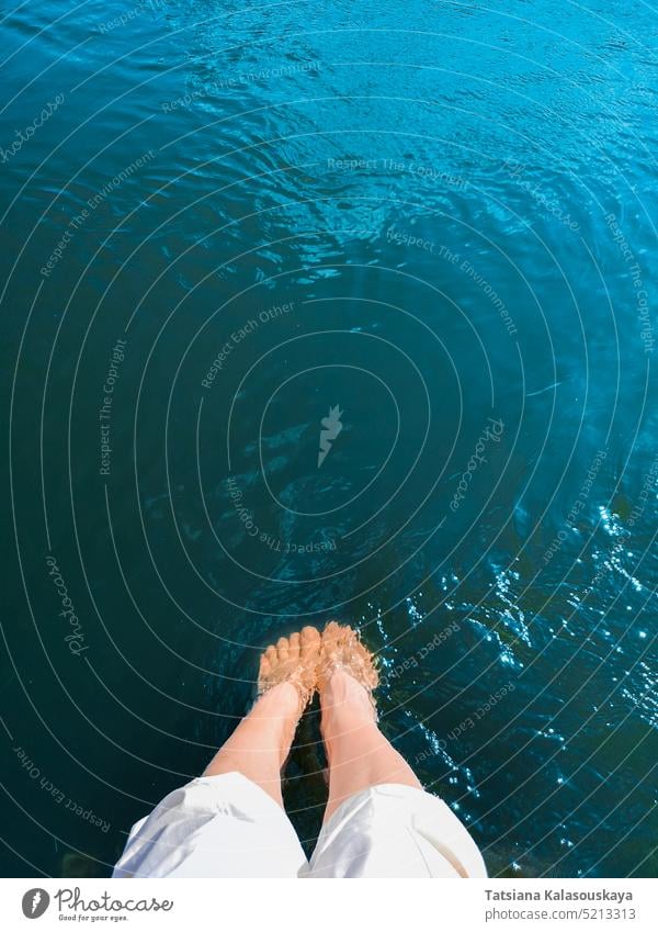 Eine Frau taucht ihre Füße in türkisfarbenes Meerwasser Urlaub Wasser MEER Strand reisen blau Beine Fuß Tourismus sich[Akk] entspannen Person Feiertag Sommer