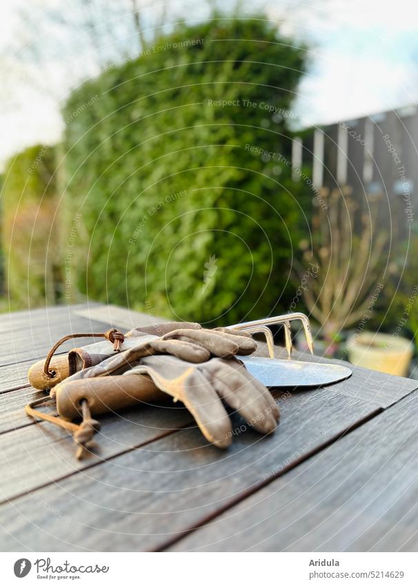 Nach der Gartenarbeit | Handschuhe und Werkzeug liegen auf dem Gartentisch Frühling Gartenhandschuhe Schaufel Dreizack ausruhen Tisch gärtnern Erde unscharf