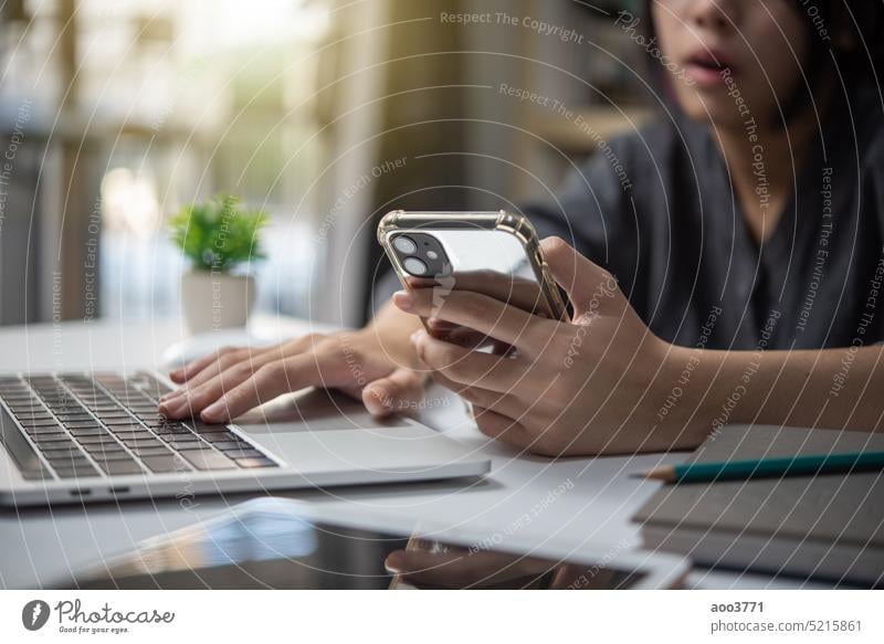 Frau, die an einem Laptop arbeitet und ein Mobiltelefon auf dem Schreibtisch benutzt, digitales Technologiekonzept. Business arbeiten Computer benutzend Mobile