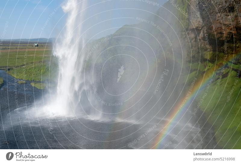 Ein Regenbogen vor dem Seljalandsfoss-Wasserfall an der Südküste Islands an einem sonnigen Tag schön Kaskade Umwelt fallen fließen grün Landschaft