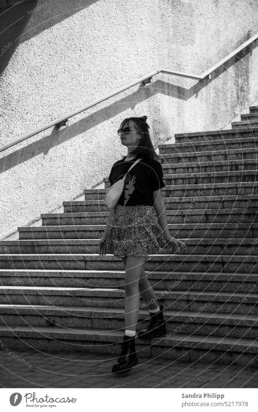 Junge Frau geht eine Treppe runter schwarz weiss cool Stiefel Rock Beine Sonnenbrille Mensch feminin Außenaufnahme Erwachsene Mode Bekleidung Kleid Lifestyle