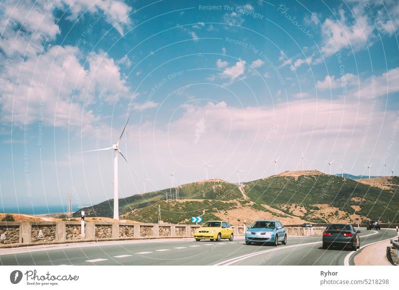 Autos Bewegung von Fahrzeugen auf Autobahn, Autobahn vor dem Hintergrund der Windmühlen, Windkraftanlagen für die Stromerzeugung. alternativ Asphalt blau