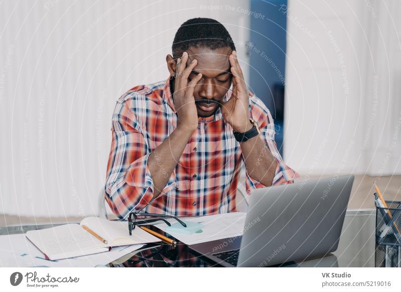 Verärgerter afroamerikanischer Angestellter gibt sich selbst die Schuld für Fehler bei der Arbeit am Laptop. Stress, Burnout Afroamerikaner männlich müde