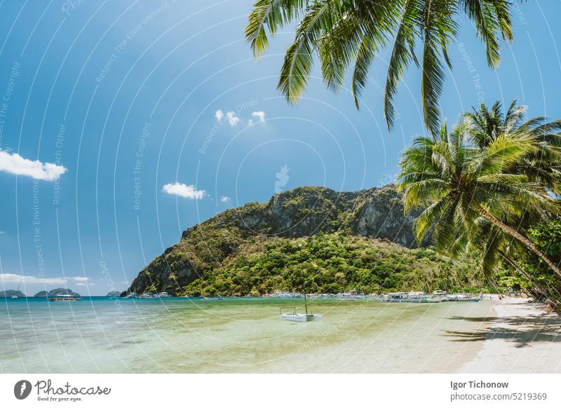 Palmen und schöne Landschaft am Strand von Corong Corong mit traditionellen Booten, Bergen und blauem Himmel in El Nido, Insel Palawan, Philippinen reisen