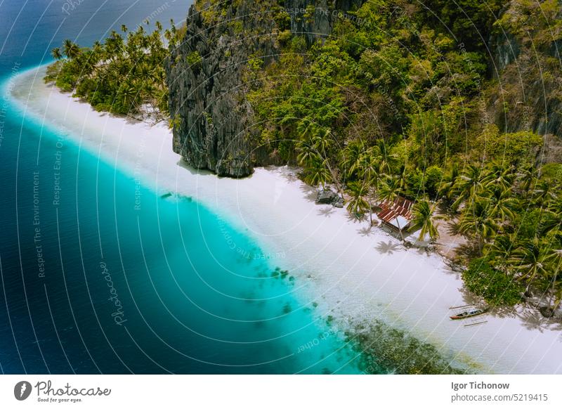 Pinagbuyutan Insel, El Nido, Palawan, Philippinen. Luftaufnahme einer tropischen Hütte umgeben von Felsen, weißem Sandstrand, Kokosnusspalmen und türkisblauem Meerwasser