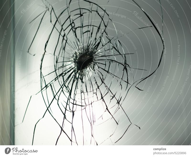 Dicke Glasscheibe mit Beschädigung Glasfassade Glaswand durchsichtig Scheibe beschädigt beschädigung Riss risse Schuss Anschlag Bruch glasbruch kreisrund